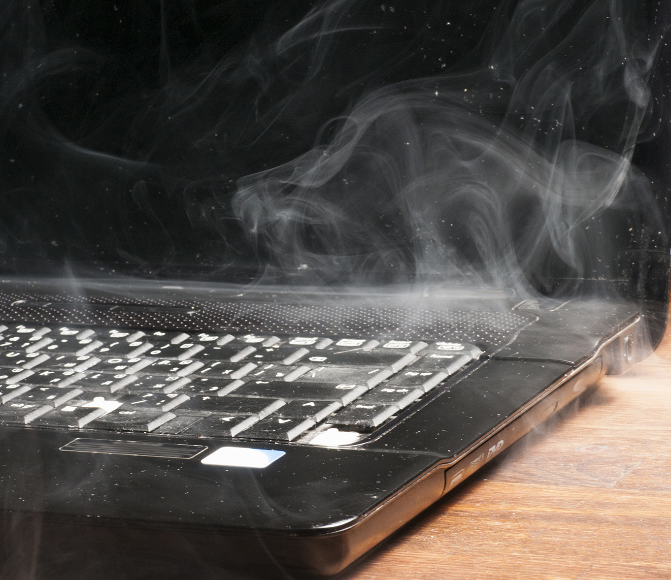 laptop computer with smoke coming from beneath it