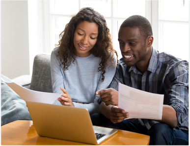 happy couple accessing a laptop